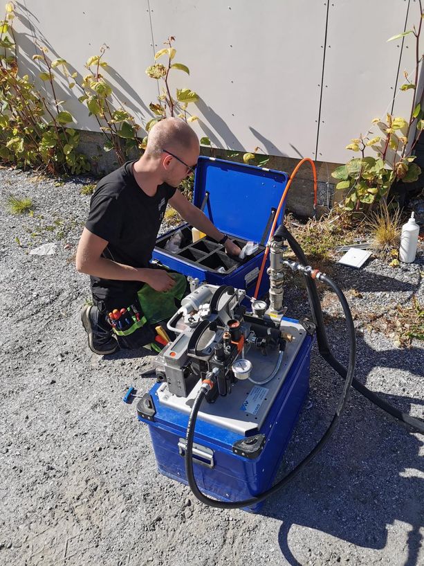 Ansatt legger fiberkabel ved et hus